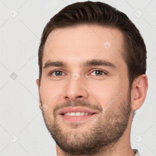 Joyful white young-adult male with short  brown hair and brown eyes