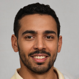 Joyful latino young-adult male with short  black hair and brown eyes