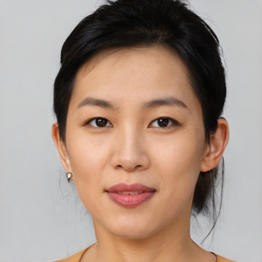 Joyful asian young-adult female with medium  black hair and brown eyes