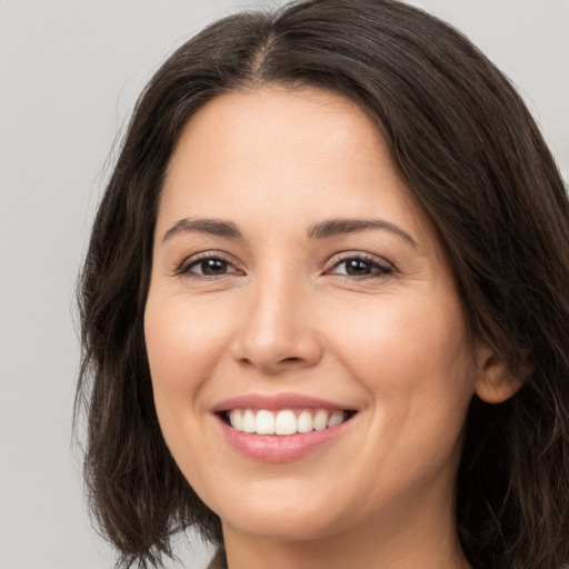 Joyful white young-adult female with long  brown hair and brown eyes