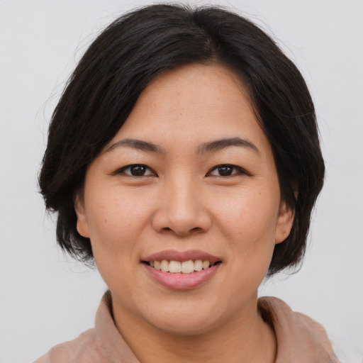 Joyful asian young-adult female with medium  brown hair and brown eyes