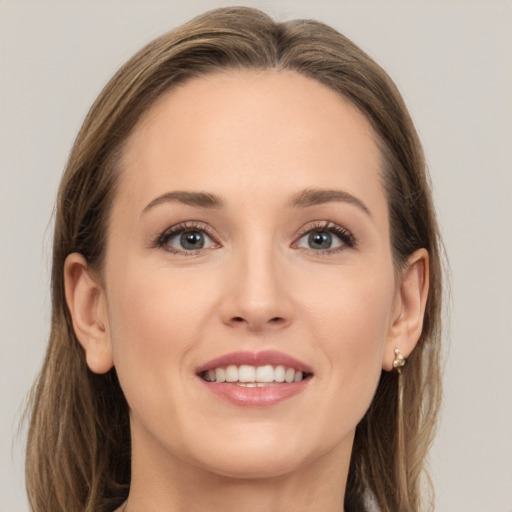 Joyful white young-adult female with long  brown hair and grey eyes