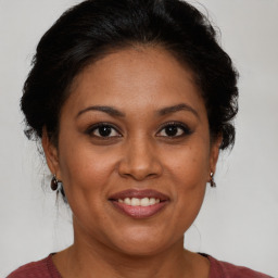 Joyful black adult female with medium  brown hair and brown eyes