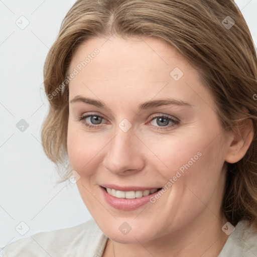 Joyful white young-adult female with medium  brown hair and blue eyes