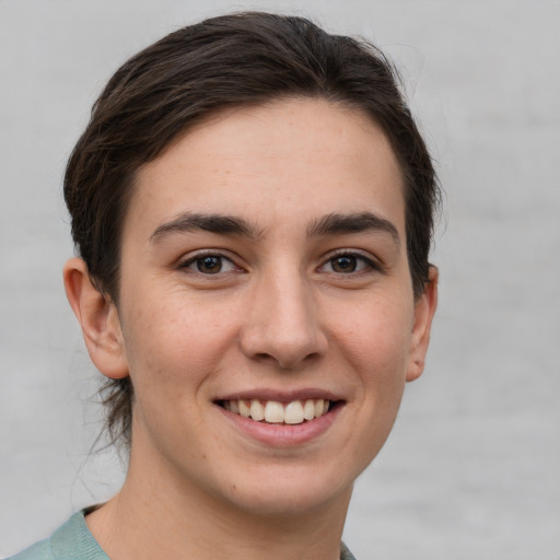 Joyful white young-adult female with short  brown hair and grey eyes