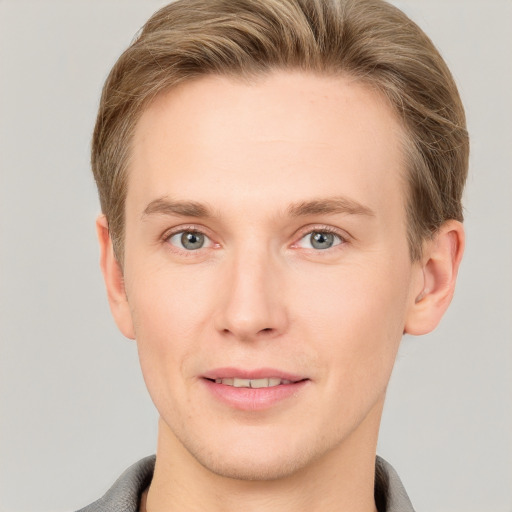 Joyful white young-adult male with short  brown hair and grey eyes