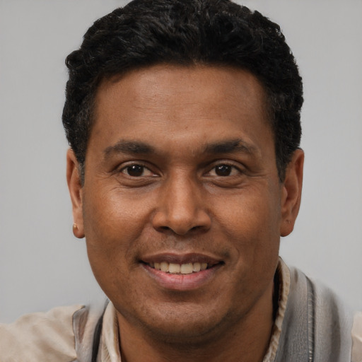 Joyful latino adult male with short  brown hair and brown eyes
