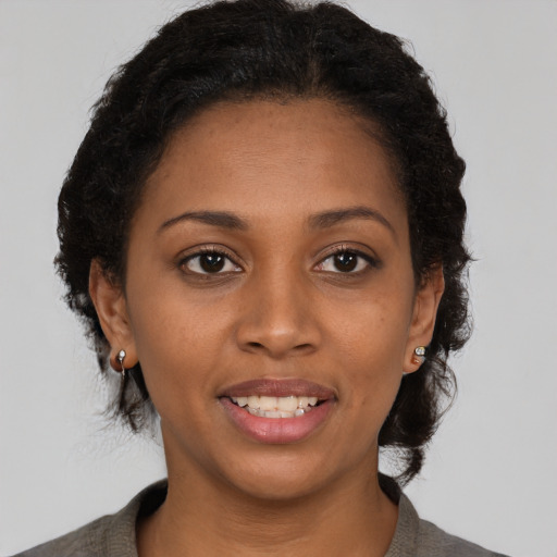 Joyful black young-adult female with short  brown hair and brown eyes