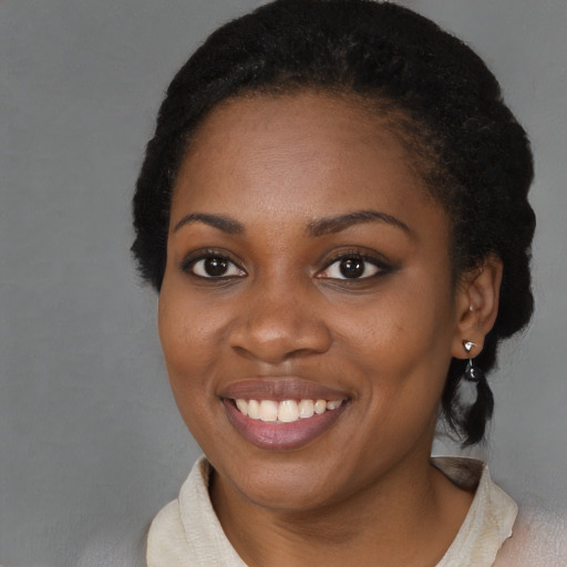 Joyful black young-adult female with short  black hair and brown eyes