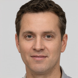 Joyful white adult male with short  brown hair and grey eyes