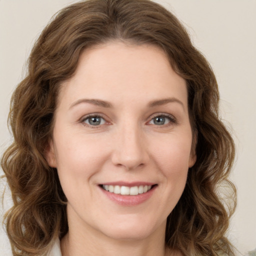 Joyful white young-adult female with long  brown hair and green eyes