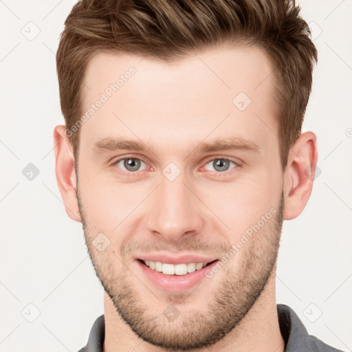 Joyful white young-adult male with short  brown hair and grey eyes