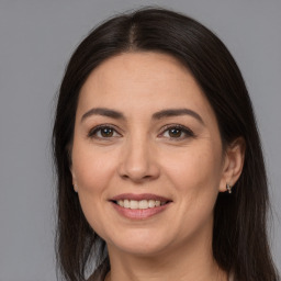 Joyful white adult female with long  brown hair and brown eyes