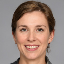 Joyful white adult female with medium  brown hair and grey eyes