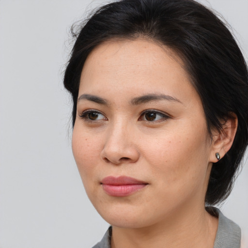 Joyful asian young-adult female with medium  brown hair and brown eyes