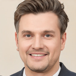 Joyful white young-adult male with short  brown hair and grey eyes