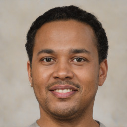 Joyful black young-adult male with short  black hair and brown eyes