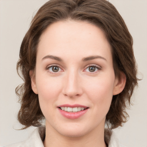 Joyful white young-adult female with medium  brown hair and green eyes