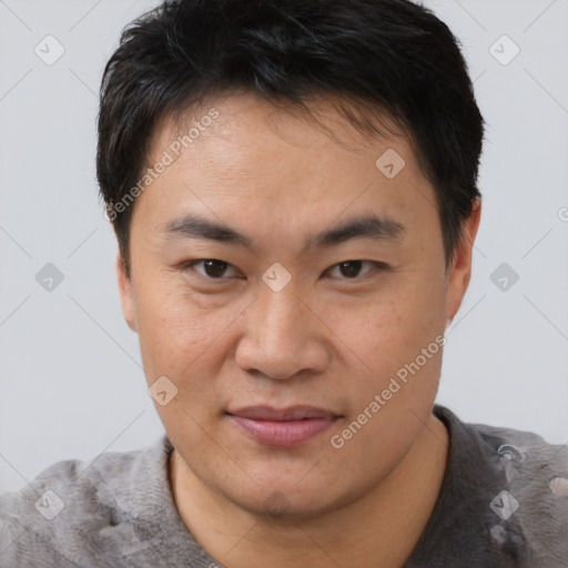 Joyful asian young-adult male with short  brown hair and brown eyes