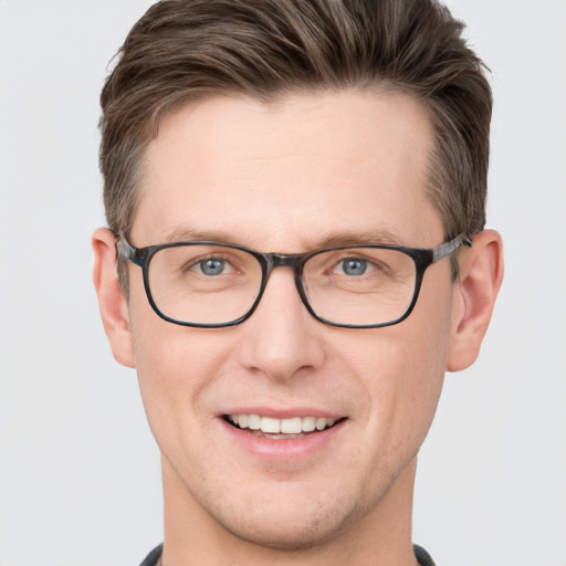 Joyful white young-adult male with short  brown hair and grey eyes