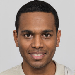 Joyful black young-adult male with short  black hair and brown eyes