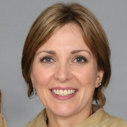 Joyful white adult female with medium  brown hair and blue eyes