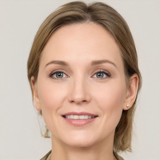 Joyful white young-adult female with medium  brown hair and grey eyes