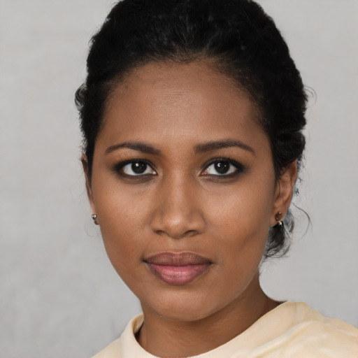 Joyful black young-adult female with short  black hair and brown eyes