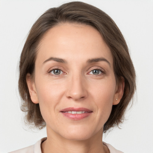 Joyful white adult female with medium  brown hair and grey eyes