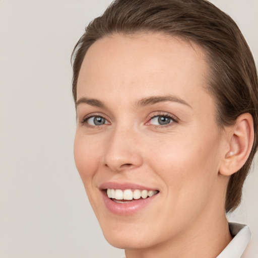 Joyful white young-adult female with medium  brown hair and grey eyes