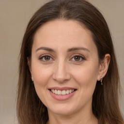 Joyful white adult female with long  brown hair and brown eyes