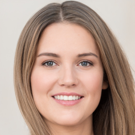 Joyful white young-adult female with long  brown hair and green eyes