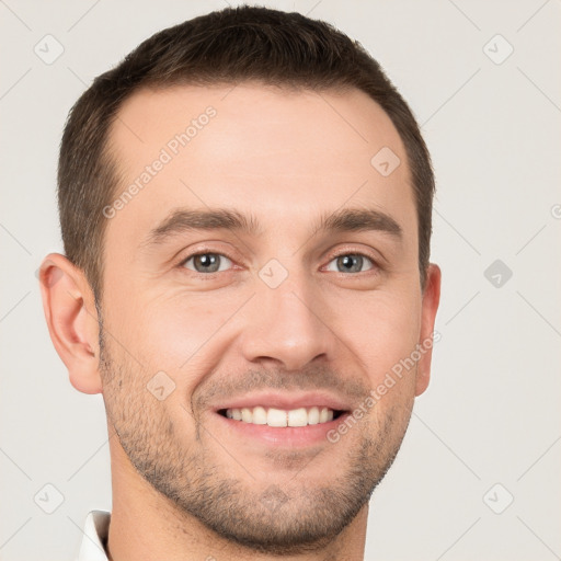 Joyful white young-adult male with short  brown hair and grey eyes