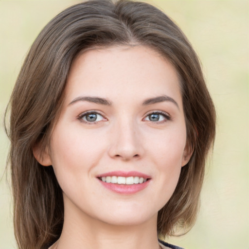 Joyful white young-adult female with medium  brown hair and green eyes