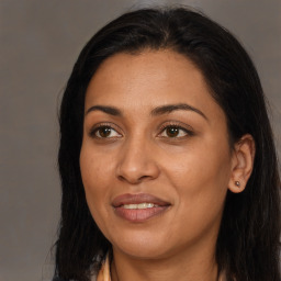 Joyful black adult female with long  brown hair and brown eyes