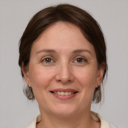 Joyful white adult female with medium  brown hair and grey eyes