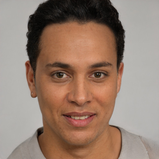 Joyful latino young-adult male with short  black hair and brown eyes