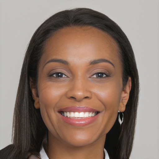 Joyful black young-adult female with long  brown hair and brown eyes