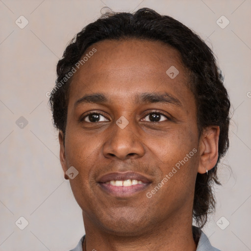 Joyful black young-adult male with short  brown hair and brown eyes