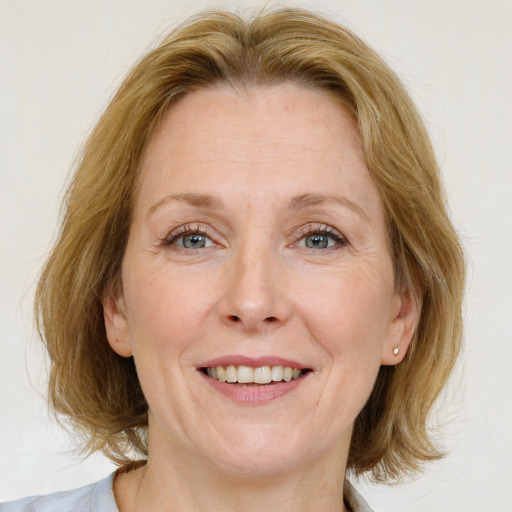 Joyful white adult female with medium  brown hair and blue eyes