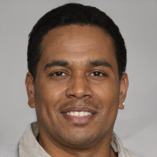 Joyful latino adult male with short  brown hair and brown eyes