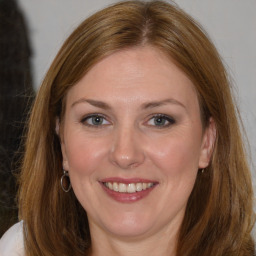 Joyful white adult female with medium  brown hair and brown eyes