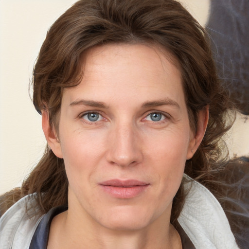 Joyful white young-adult female with medium  brown hair and blue eyes