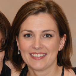 Joyful white adult female with medium  brown hair and brown eyes