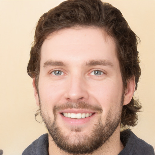 Joyful white young-adult male with short  brown hair and green eyes