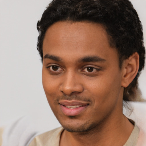 Joyful black young-adult male with short  black hair and brown eyes