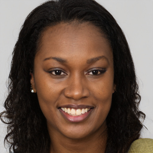 Joyful black young-adult female with long  brown hair and brown eyes