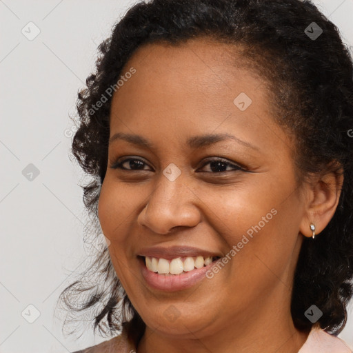 Joyful black young-adult female with medium  brown hair and brown eyes