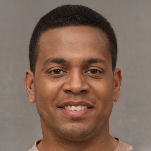 Joyful latino young-adult male with short  brown hair and brown eyes