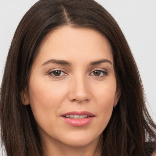 Joyful white young-adult female with long  brown hair and brown eyes